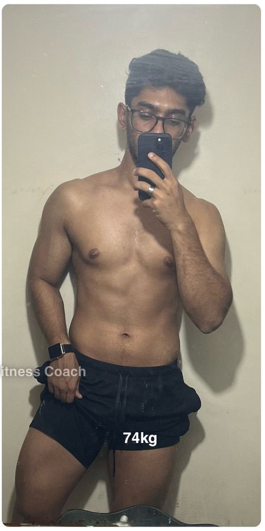 Kunal after: a shirtless mirror selfie in shorts, visibly more muscular and leaner, 74 kg.